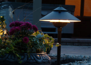An outdoor light next to a flower planter